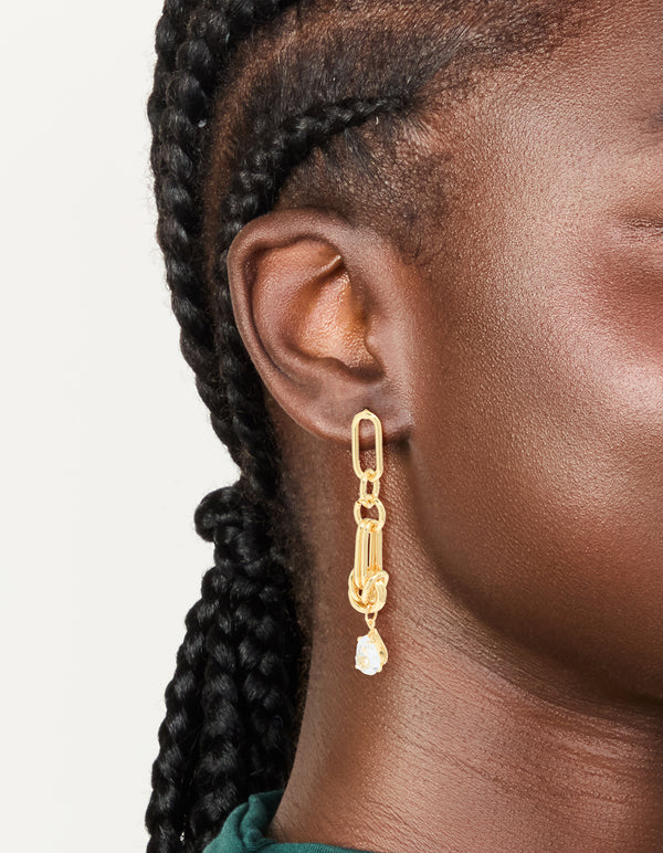 Discover these statement drop earrings crafted from gold plated metal featuring with knotted link design and cubic zirconia stones on ear view