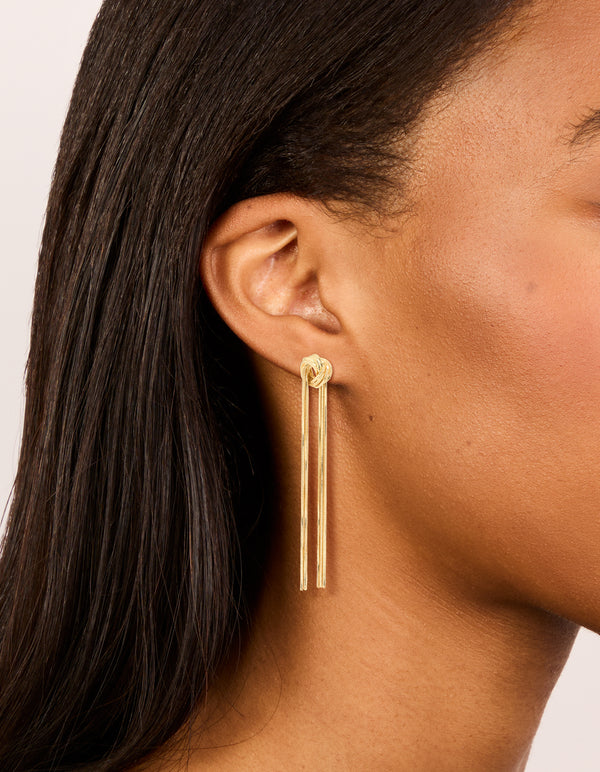 Crafted from gold plated material, these statement fringe knot earrings on ear view