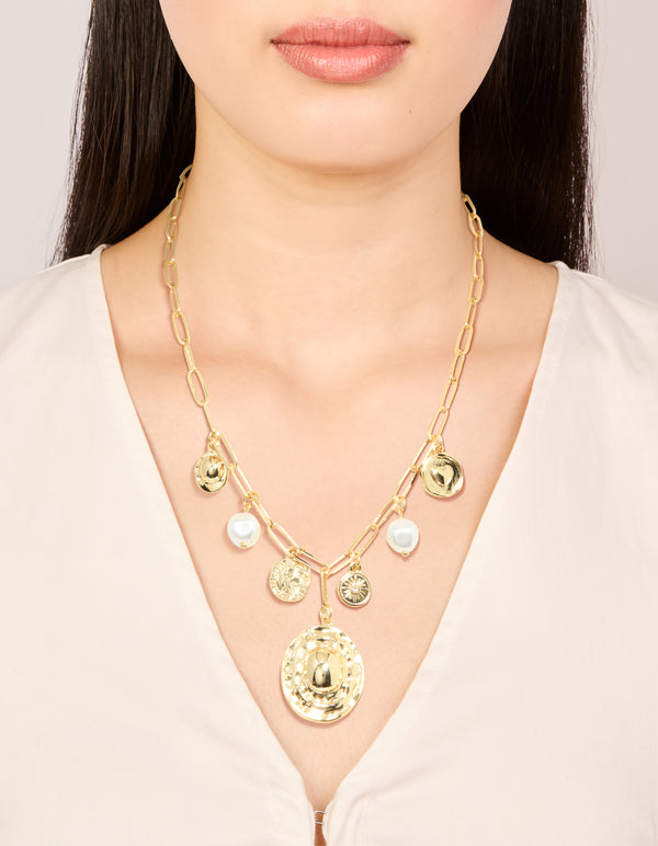 Featuring gold plated statement circle charm chain necklace with pearl, sun and coin accents on neck view
