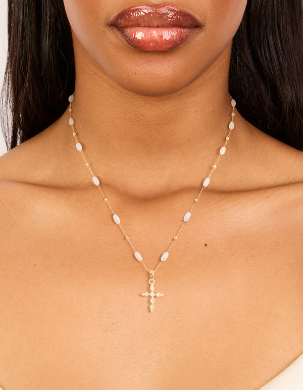 Showcasing a gold plated cubic zirconia cross and pearl necklace on neck view