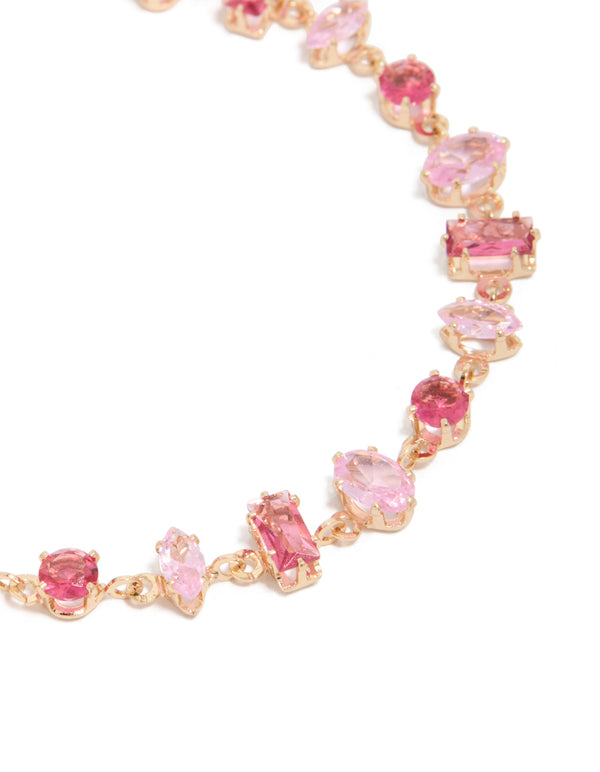 Delicate bracelet with light pink and hot pink cubic zirconia in a dainty gold design close up view