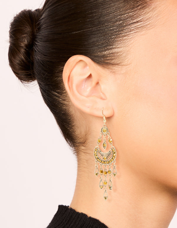 Showcasing gold boho dangly drop charm earrings on ear view