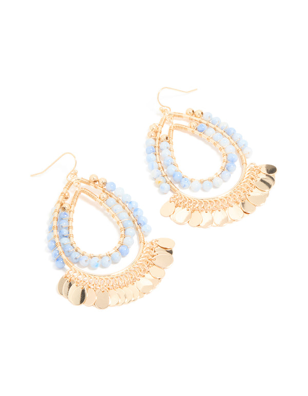 Showcasing statement teardrop earrings featuring blue beads and gold disc accents in a layered design front view