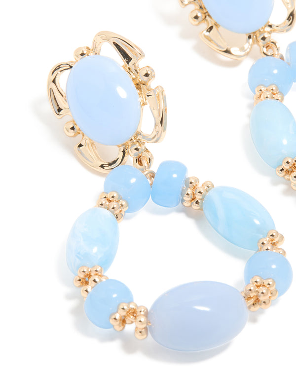 Elegant gold light blue beaded oval drop earrings in close up view
