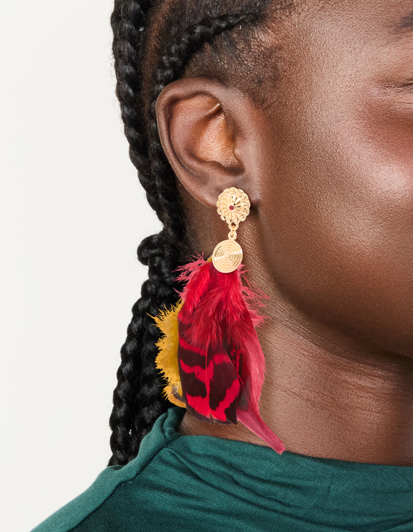 Showcasing statement drop earrings in gold with hot pink and yellow feather on ear view