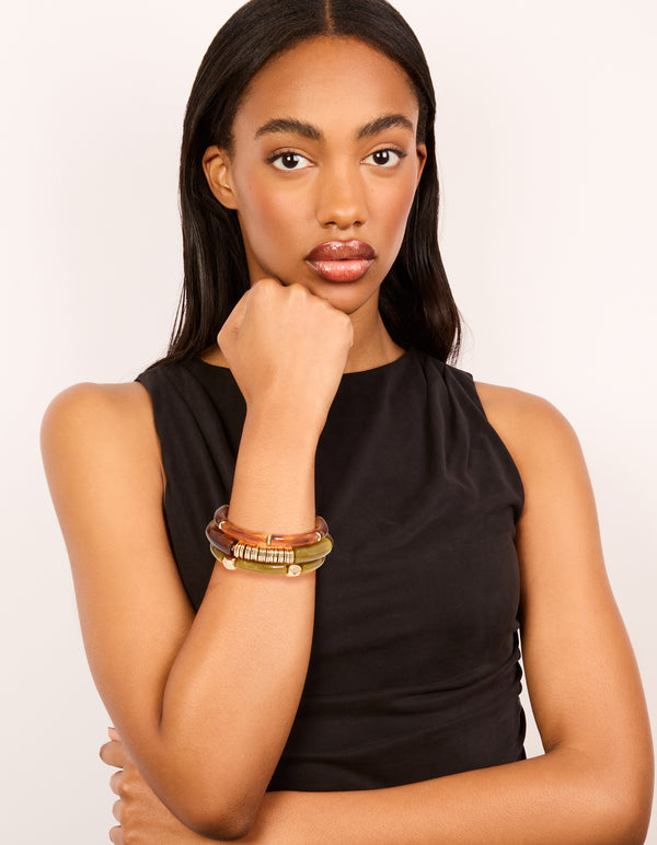 Styled brown and green resin stretch bracelets in a 3-pack crafted in gold material on model view