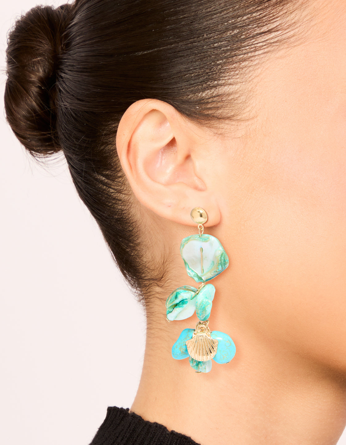 Discover these statement layered drop earrings featuring ocean-inspired charm details with genuine shell disc accents in turquoise and gold on ear view