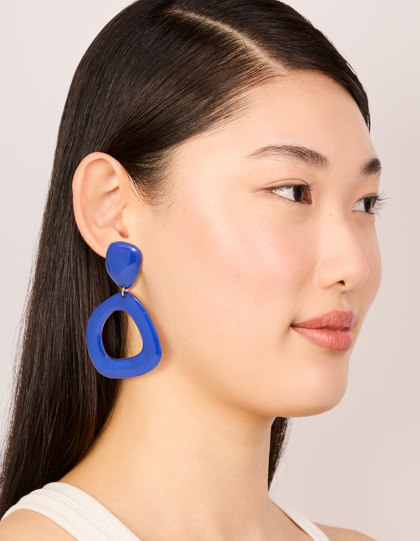 Displaying dark blue acrylic organic square-oval drop earrings in statement style with on model view