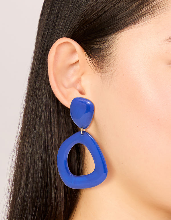 Showcasing dark blue acrylic organic square-oval drop earrings in statement style with on ear view