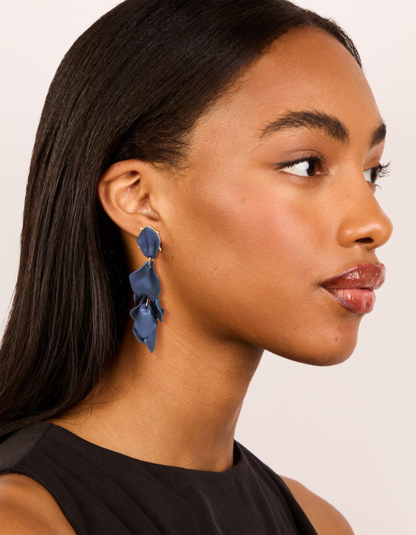 Beautifully crafted navy blue coated metal flower petal drop earrings with gold details with on model view