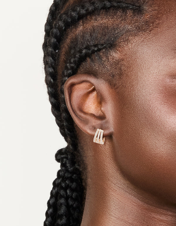 Detailed view of rose gold plated cubic zirconia layered hoop earrings on ear view