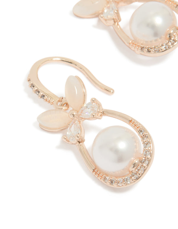 Featuring white pearl center surrounded by cubic zirconia in oval cut, butterfly charm hook earrings with rose gold plated finish close up view