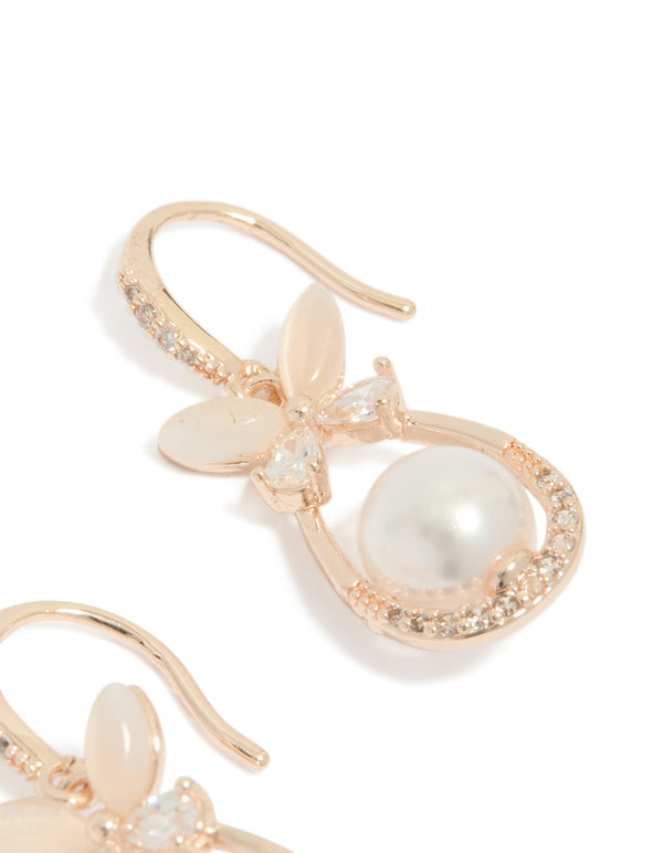 Highlighting the intricate floral butterfly design with dainty white pearl and cubic zirconia stones in rose gold plated metal post detail view