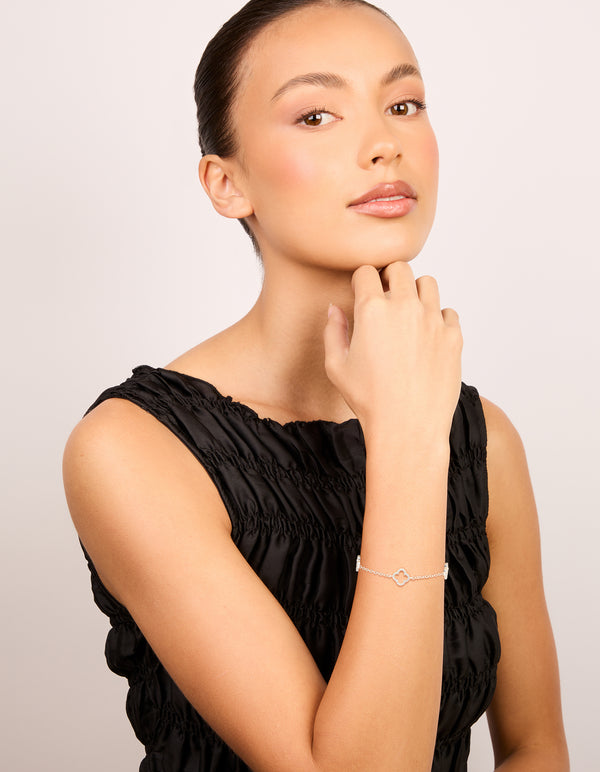This silver plated cubic zirconia outline flower bracelet shown in a styled setting on model view