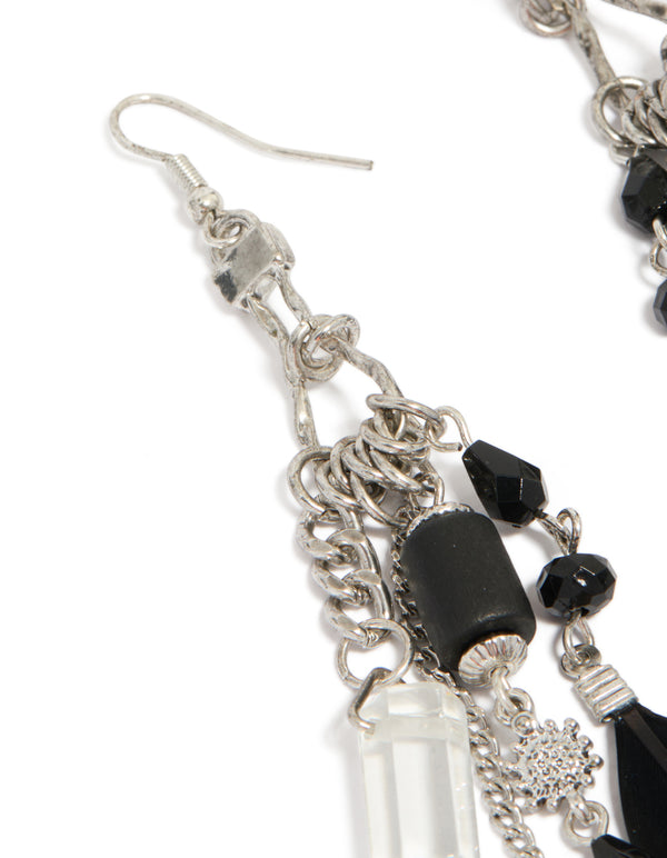 Detailed view of antique silver black feather and chain drop earrings with beads, charms accents close up view