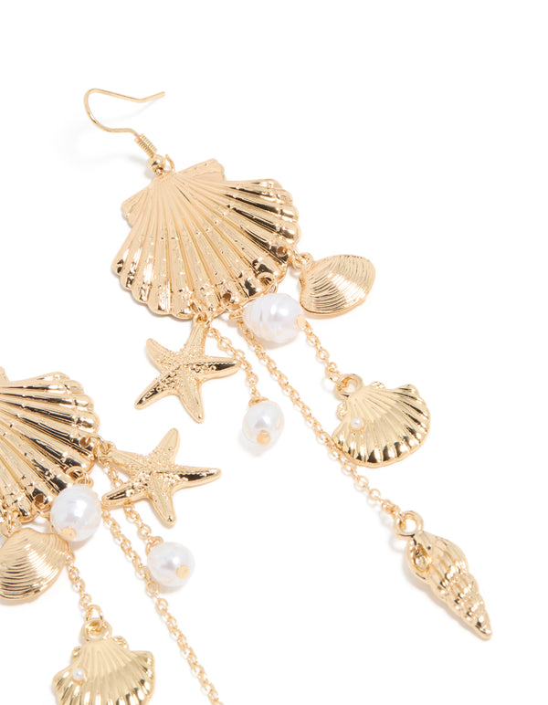 Beautifully crafted gold pearl and multi shell drop earrings with ocean-inspired charm details in white close up view