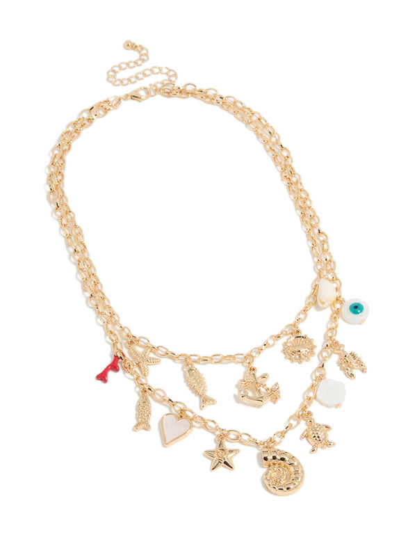 Beautifully styled gold layered necklace featuring charms, evil-eye, heart, ocean-themed shell details, front view