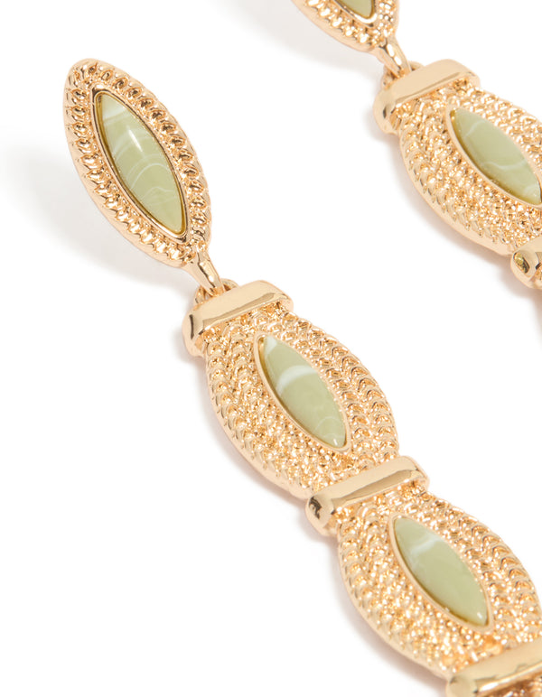 Beautifully crafted pale green stone set in gold with intricate detailing close up view