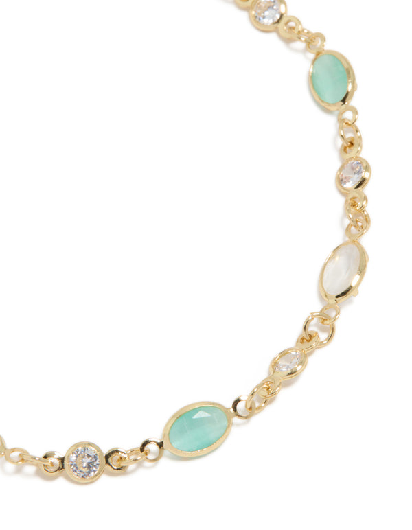 Elegant gold plated bracelet with clear and blue cubic zirconia in oval stone close up view