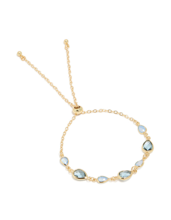Featuring bracelet crafted from gold plated metal with deep blue cubic zirconia stones in a statement design front view