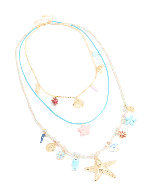 Crafted from gold blue cord, this sea charm layered necklace features floral, leaf, ocean and coin front view