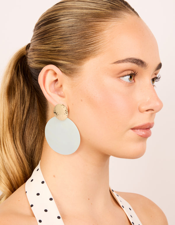 Featuring ocean-inspired design, these hammered gold and white genuine shell statement drop earrings on model view