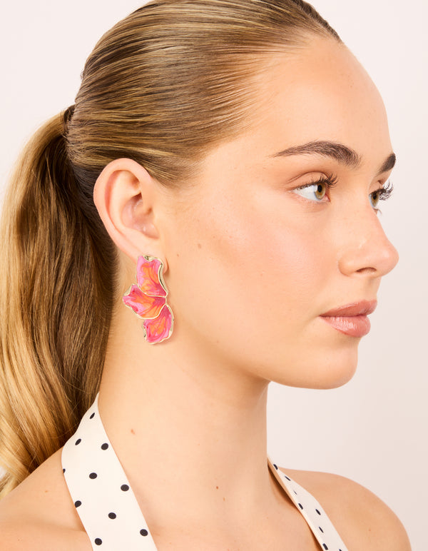 Styled small half flower earrings featuring enamel in light pink, orange, and hot pink tones with gold on model view