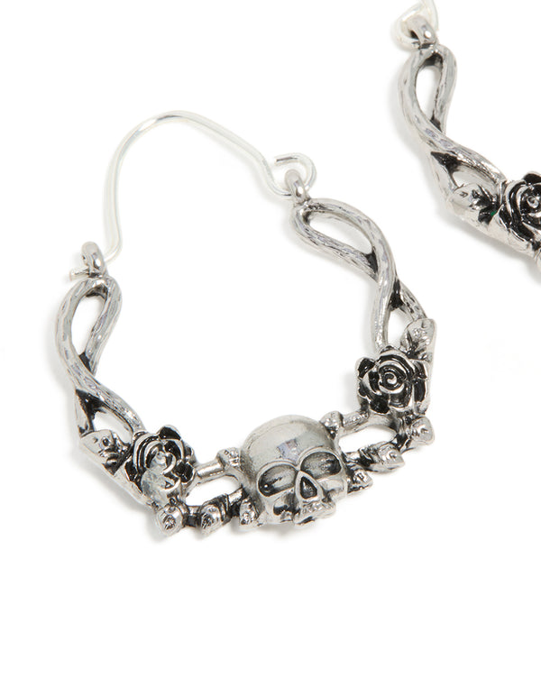 Detailed view of statement hoop earrings with skull featuring floral pattern in silver close up view