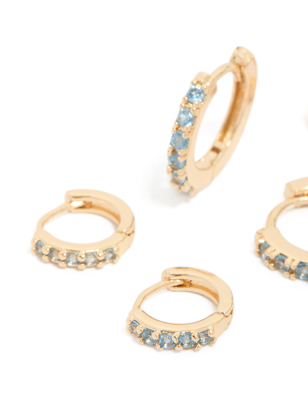 Gorgeous gold huggie earrings in a 3-pack with clear and light blue cubic zirconia stones featuring crystal details close up view