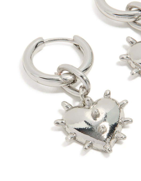 Crafted from silver, these statement huggie earrings feature heart with spike detailing close up view