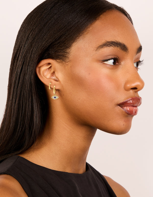Displaying waterproof gold plated stainless steel diamante evil eye huggie earrings in a 2-pack on model view
