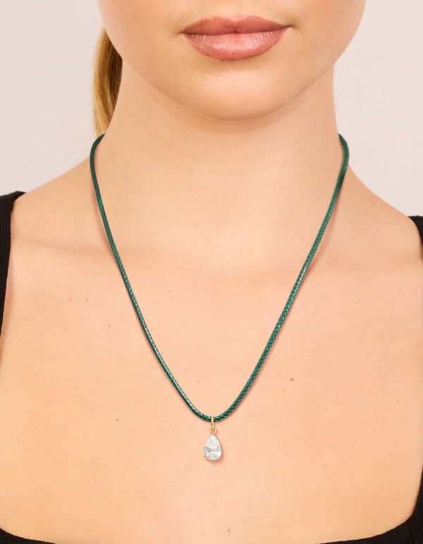 Featuring a waterproof necklace with pear cut cubic zirconia pendant on dark green cord in gold plated stainless steel and crystal on neck view