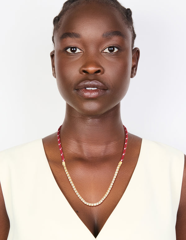 Designed with elements, this waterproof half tennis and half burgundy cord necklace in gold plated stainless steel offers a statement style on model view