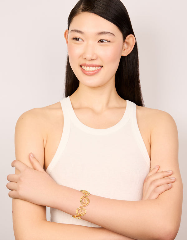 Designed with waterproof gold plated stainless steel swirl bendy wrist cuff bangle in statement styling on model view