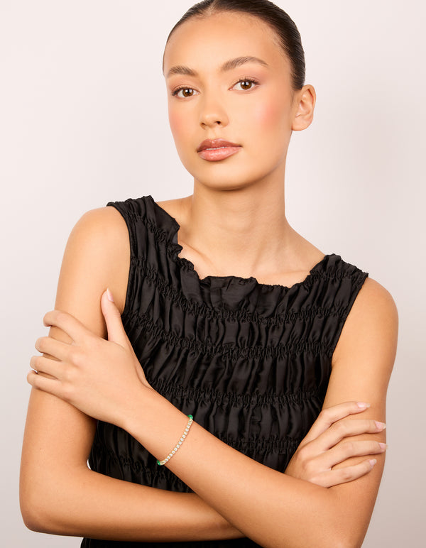 Crafted from waterproof gold plated stainless steel half tennis and half vibrant green cord bracelet with white accents in statement style on model view