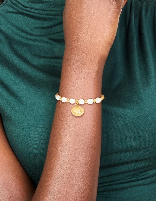 Featuring a waterproof gold plated stainless steel freshwater pearl and shell, ball bracelet with beads, ocean accents, and statement styling on wrist view