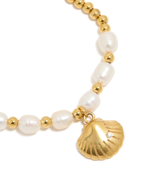 Highlighting a waterproof gold plated stainless steel freshwater pearl and shell, ball bracelet with beads, ocean accents, and statement styling close up view