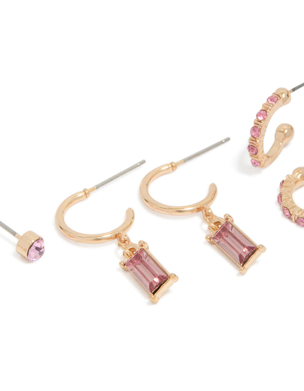 Showcasing gold hoop and stud earrings in a 3-pack with light pink diamante details close up view