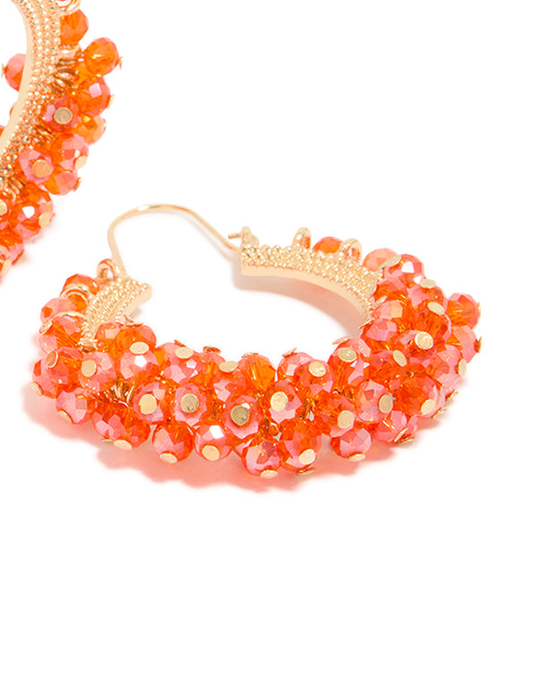Highlighting statement hoop earrings adorned with beads in coral and gold accessories post detail view
