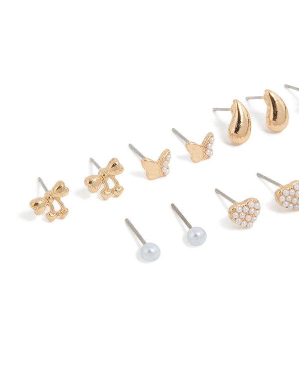 Crafted from gold with mini bow, celestial star, ball, heart, and pearl stud earrings in a 7-pack close up view