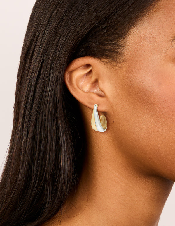Showcasing mixed metal plated layered small hoop earrings in gold and silver on ear view