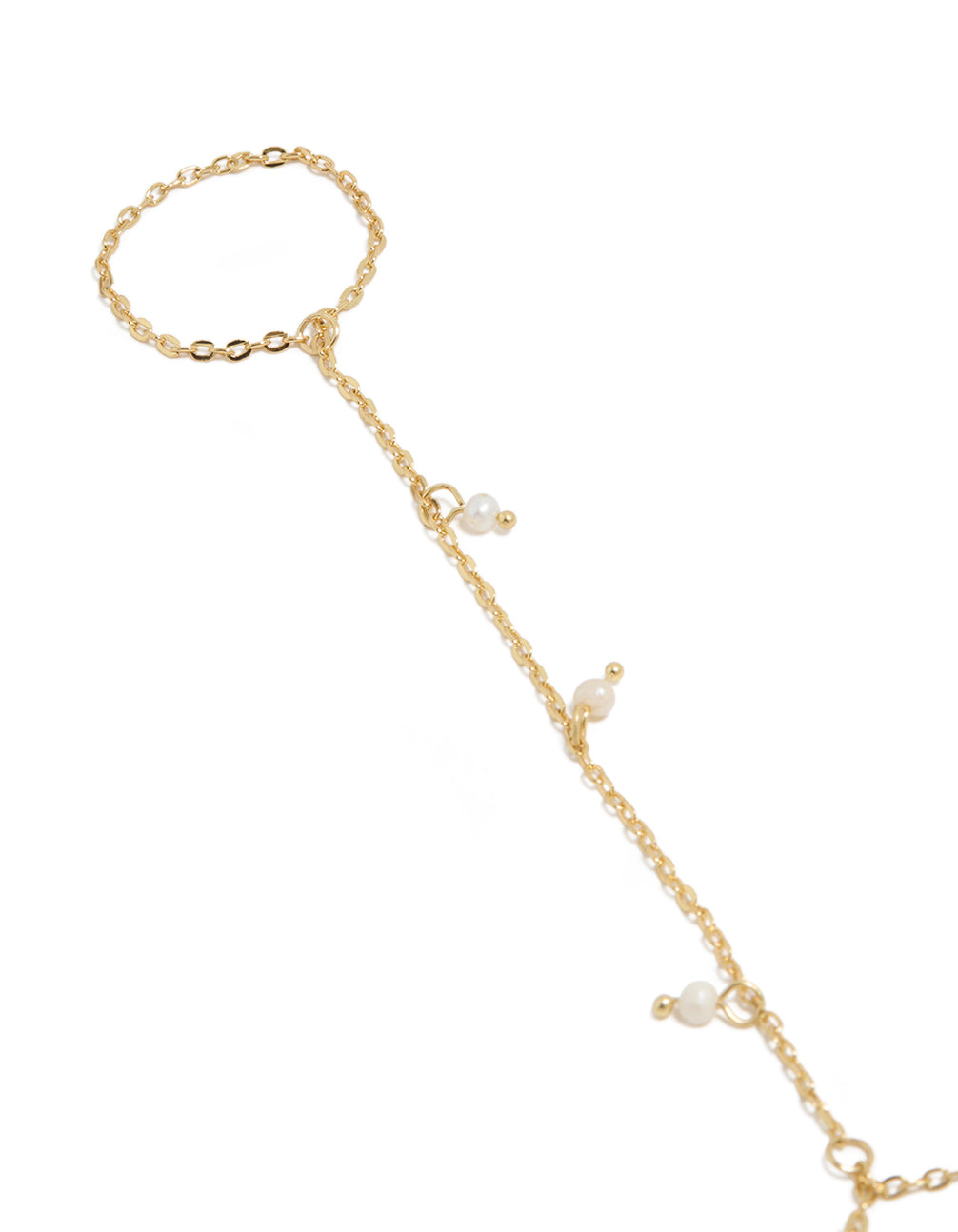 Showcasing a gold plated mini freshwater pearl droplet hand chain with charm in dainty statement style close up view