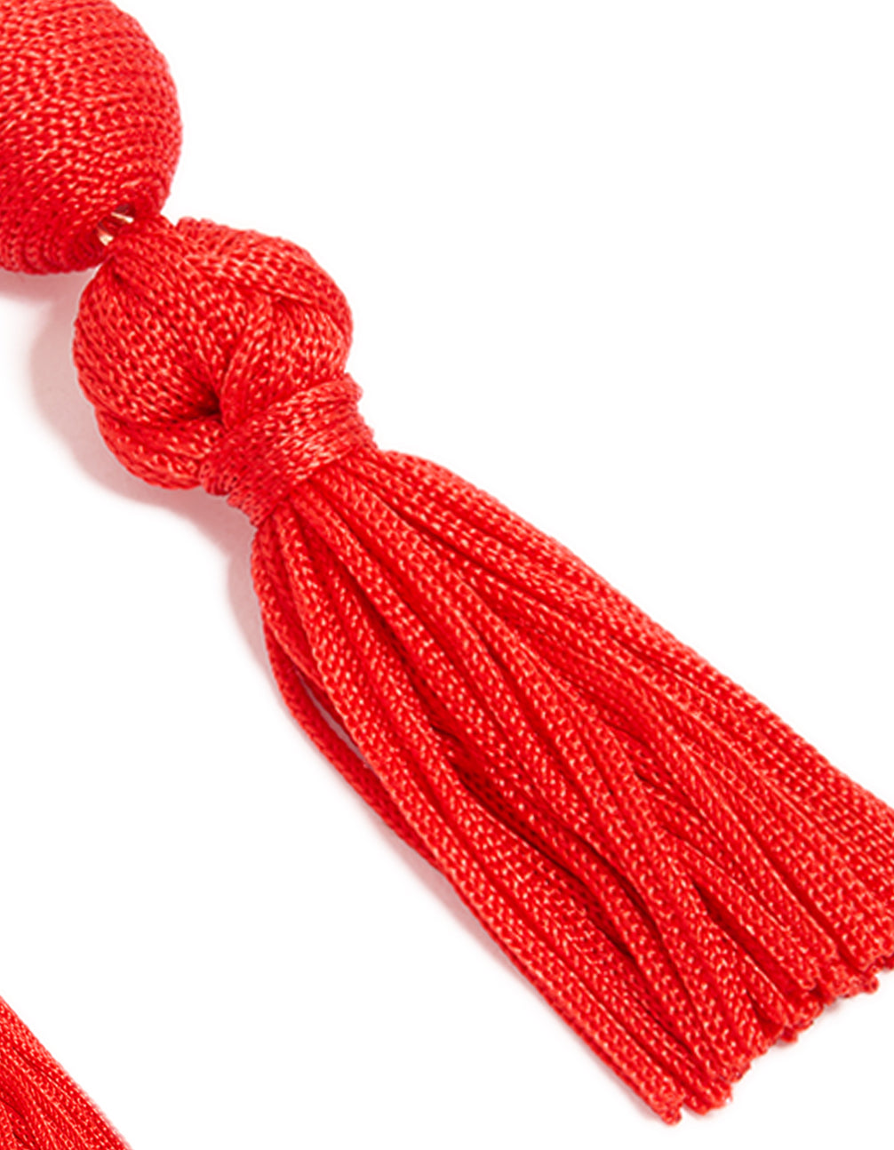 Designed with statement red fabric tassel drop earrings and gold finish post detail view