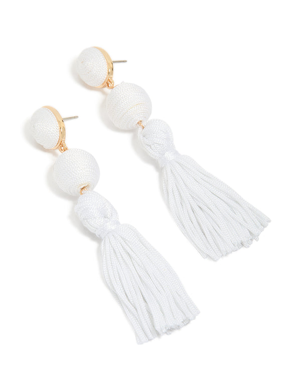Beautifully crafted white fabric tassel drop earrings featuring statement style with gold accents front view