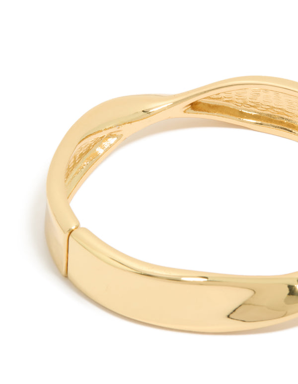 A gold plated twisted thick bangle in gold with chunky design close up view