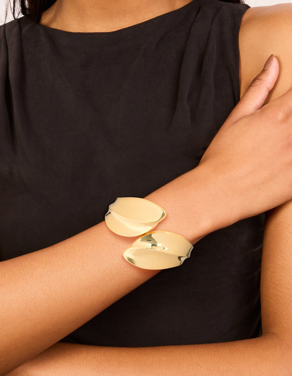 Featuring gold plated thick curved statement bangle on wrist view