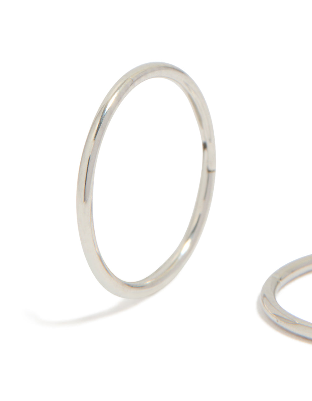 Showcasing kids surgical steel sleeper earrings with dainty, hoop closure in silver close up view