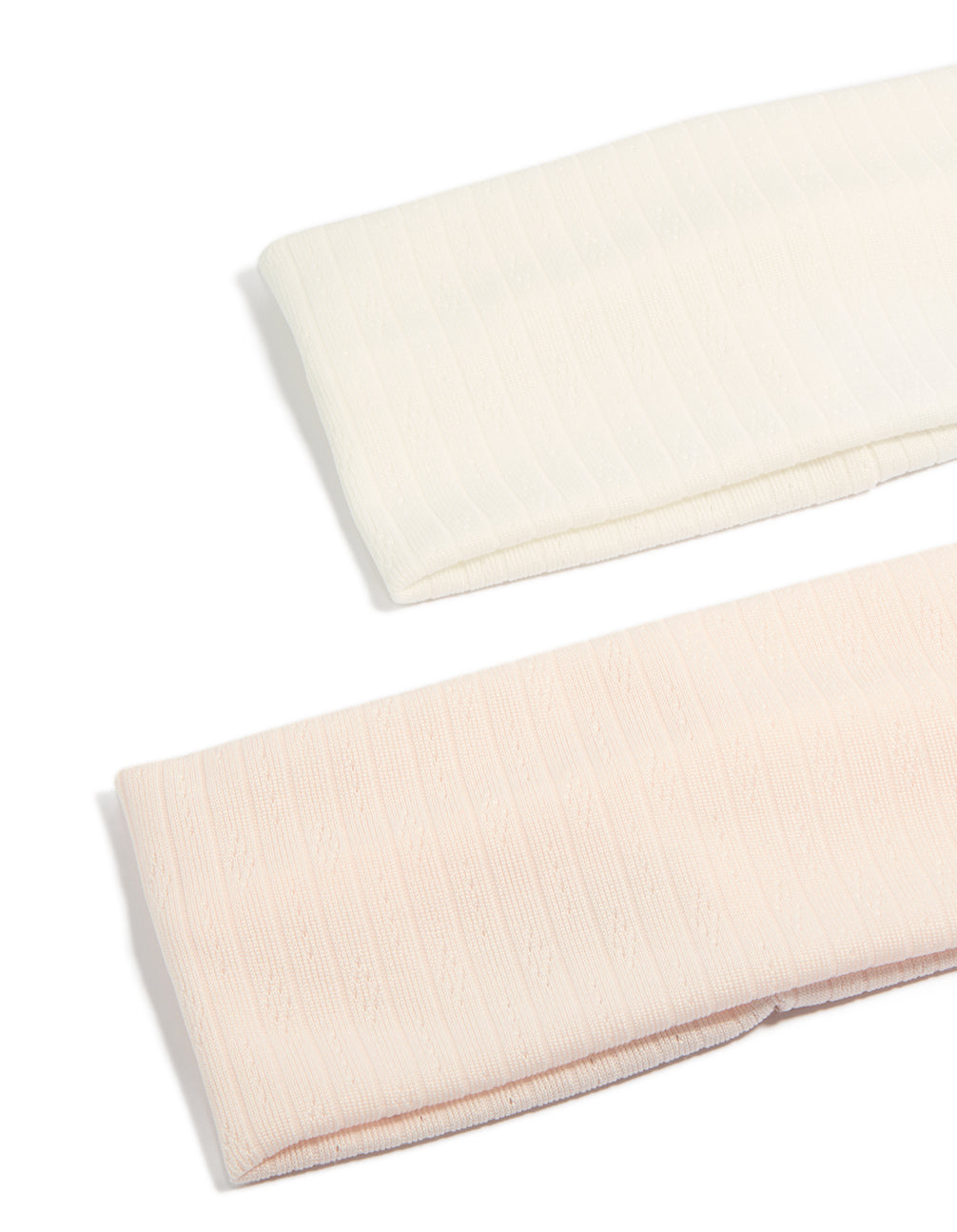 Featuring solid pointelle fabric stretch headbands in a 2-pack with ivory and pink colorways detail view
