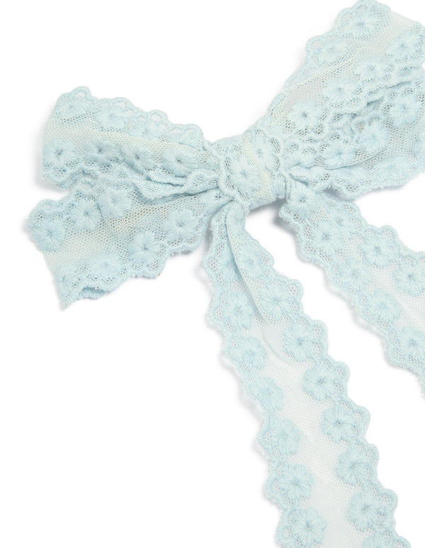 Showcasing floral fabric bow hair clip in light blue with textured knot center, detail view