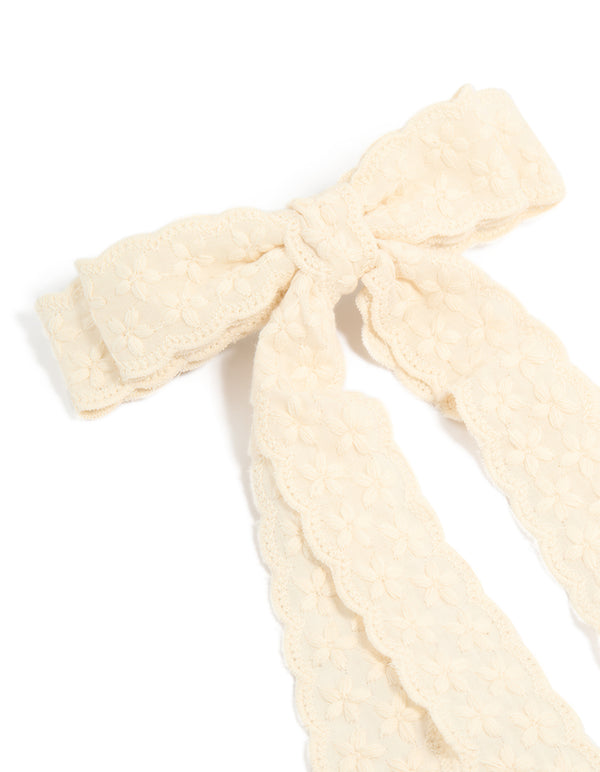 Crafted from textured lace, this ivory bow clip side view